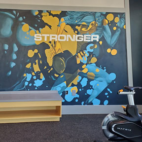 photo of gold and teal fitness center mural